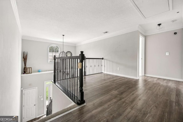 staircase with a textured ceiling, hardwood / wood-style flooring, and crown molding