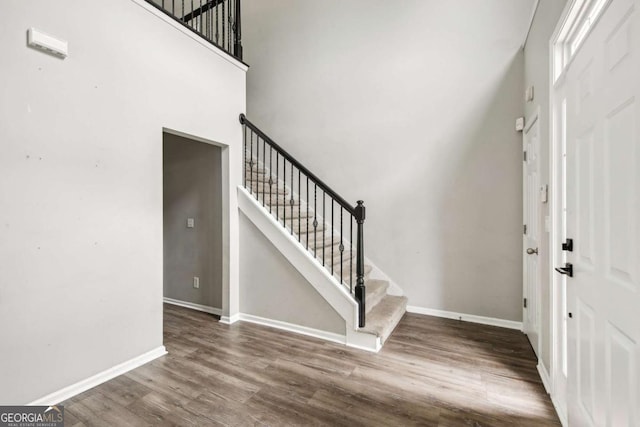 foyer entrance featuring hardwood / wood-style flooring and a towering ceiling