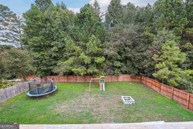 view of yard featuring a playground and a trampoline