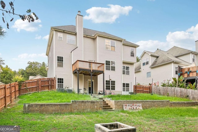 rear view of property featuring a deck and a lawn