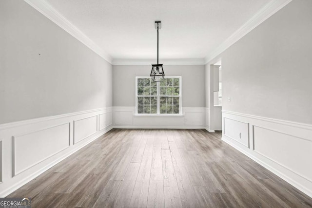 unfurnished dining area featuring hardwood / wood-style flooring and crown molding