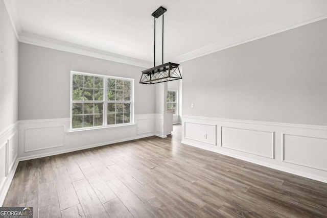 unfurnished dining area featuring wood-type flooring and ornamental molding