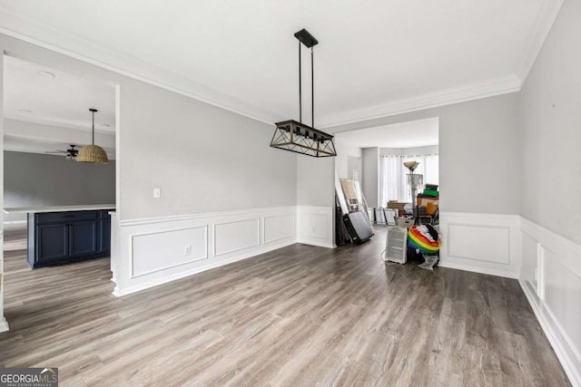 unfurnished dining area with hardwood / wood-style flooring, ceiling fan, and ornamental molding