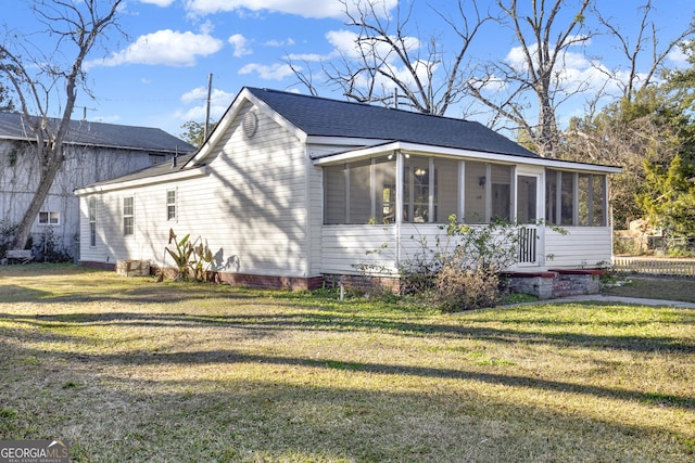 view of side of property featuring a lawn and a sunroom