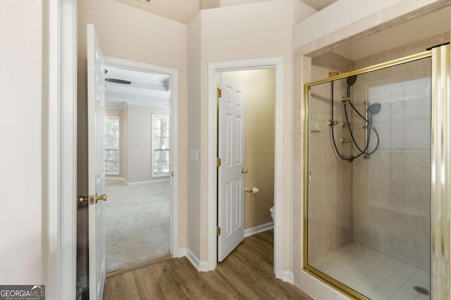 bathroom featuring hardwood / wood-style floors, toilet, and an enclosed shower