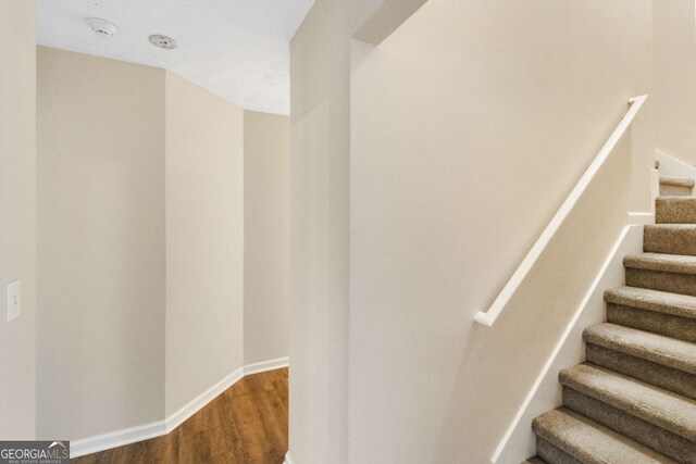 staircase with hardwood / wood-style flooring