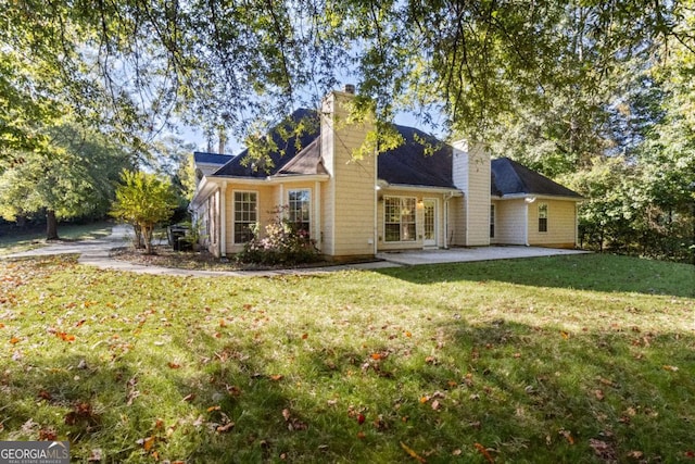 back of house with a lawn and a patio