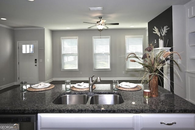 kitchen featuring dark stone counters, dishwashing machine, ceiling fan, sink, and white cabinets