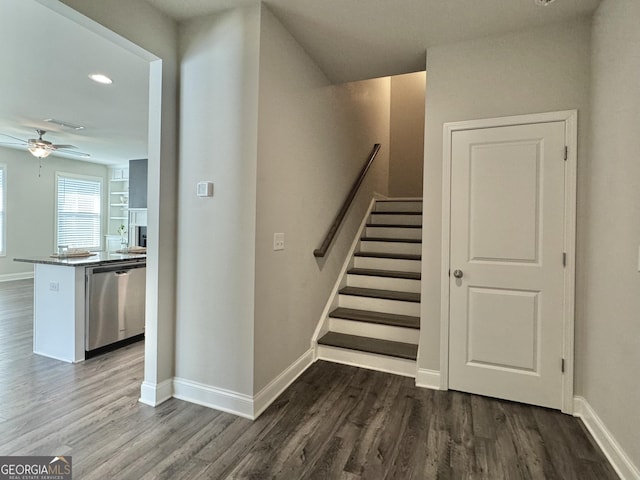 stairs featuring ceiling fan and wood-type flooring