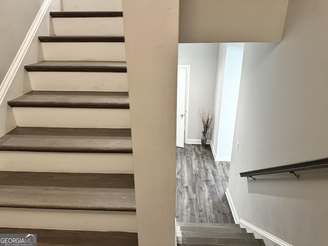 staircase with hardwood / wood-style flooring