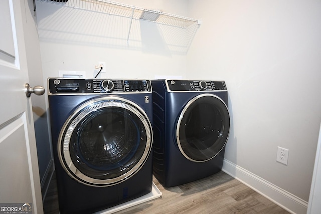 laundry room with hardwood / wood-style floors and washing machine and dryer