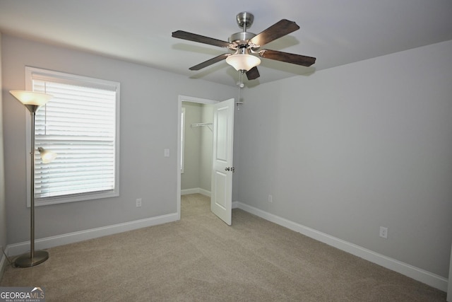 unfurnished bedroom featuring multiple windows, ceiling fan, a closet, and light carpet