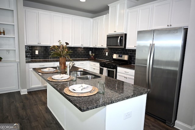 kitchen featuring a kitchen island with sink, white cabinets, and appliances with stainless steel finishes