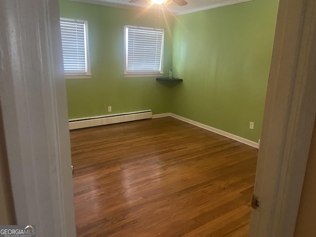 unfurnished room featuring a baseboard radiator, wood-type flooring, and crown molding