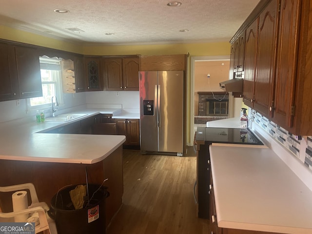 kitchen featuring sink, hardwood / wood-style flooring, stainless steel fridge with ice dispenser, a textured ceiling, and range