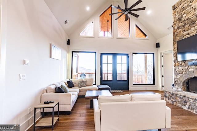 living room featuring a fireplace, hardwood / wood-style floors, high vaulted ceiling, and ceiling fan