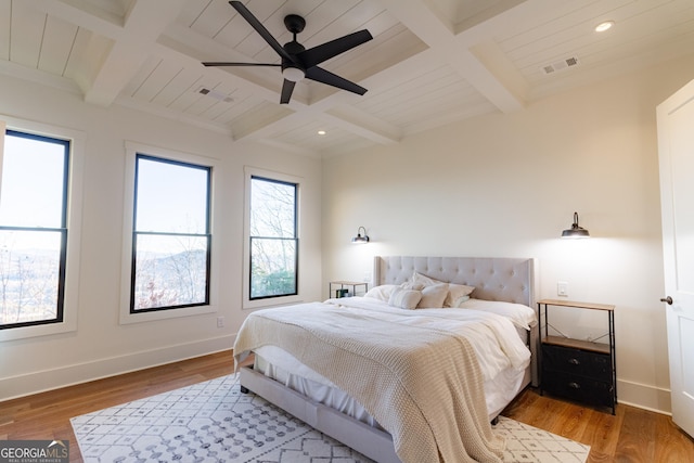 bedroom featuring beamed ceiling, hardwood / wood-style floors, and ceiling fan