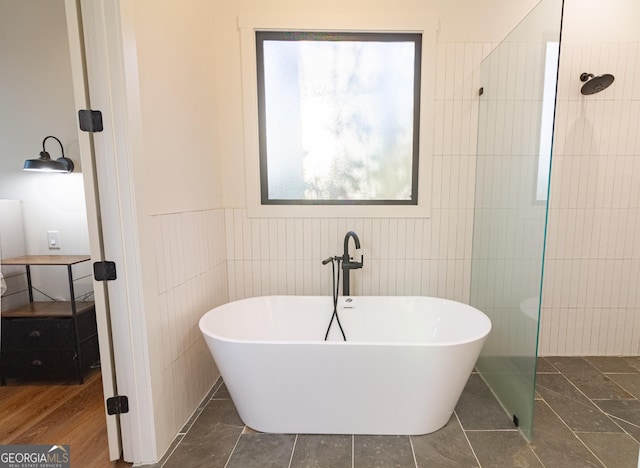 bathroom featuring independent shower and bath and a healthy amount of sunlight