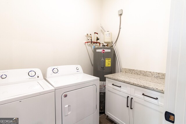 washroom with electric water heater, cabinets, and separate washer and dryer