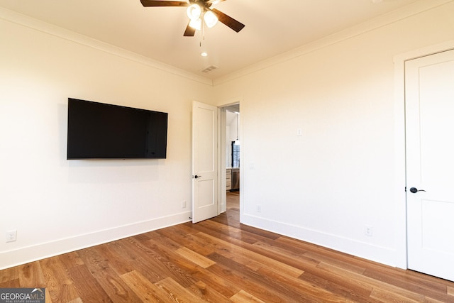 unfurnished bedroom featuring hardwood / wood-style floors, ceiling fan, and crown molding