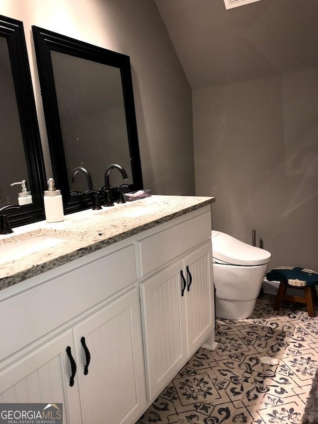 bathroom featuring toilet, tile patterned flooring, lofted ceiling, and vanity