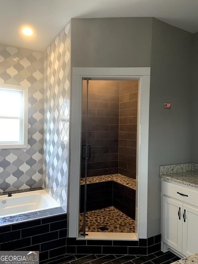 bathroom featuring tile patterned flooring, independent shower and bath, and vanity