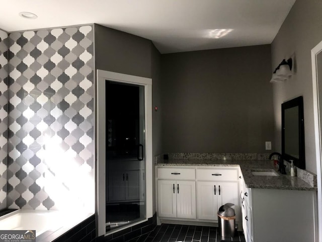 kitchen with white cabinets, dark stone countertops, dark tile patterned flooring, and sink