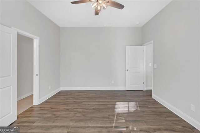 spare room featuring ceiling fan and dark wood-type flooring