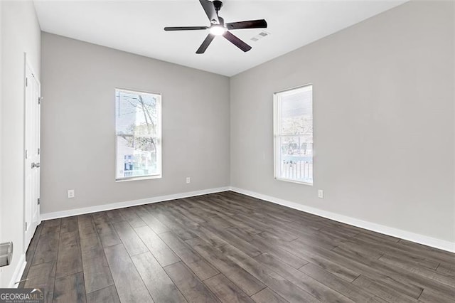 unfurnished room featuring plenty of natural light, dark wood-type flooring, and ceiling fan