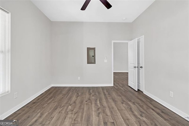 spare room with ceiling fan, dark wood-type flooring, and electric panel