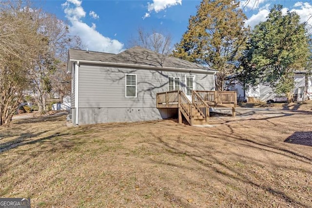 rear view of property with a deck and a lawn