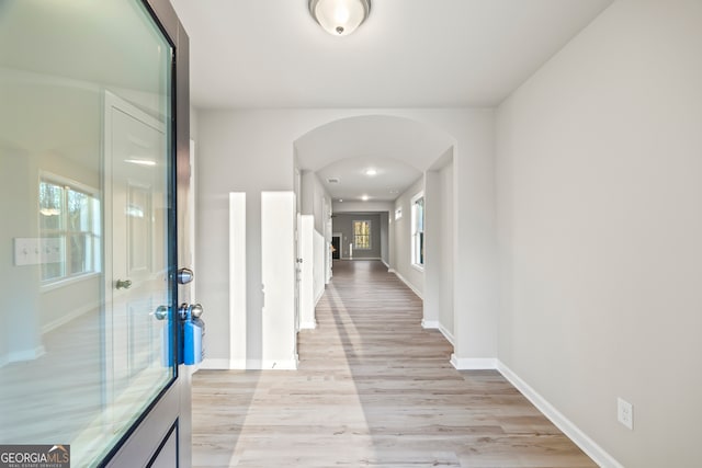 hallway featuring light hardwood / wood-style floors and a healthy amount of sunlight