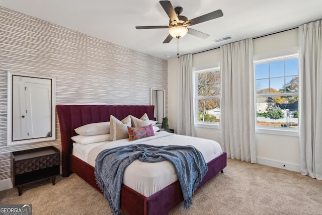 carpeted bedroom with ceiling fan and multiple windows