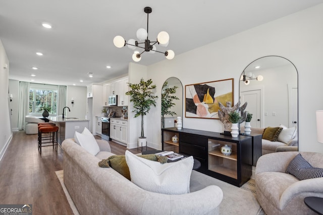 living room featuring dark hardwood / wood-style flooring, sink, and an inviting chandelier