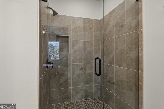 bathroom with a shower with door