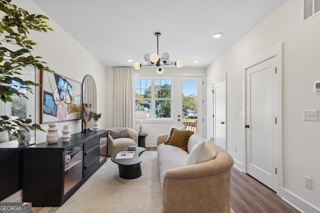 living area featuring a notable chandelier and dark hardwood / wood-style flooring