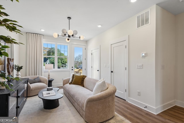 living room with wood-type flooring and an inviting chandelier