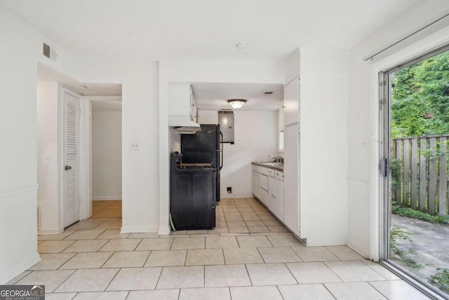 kitchen with white cabinets, light tile patterned floors, and sink