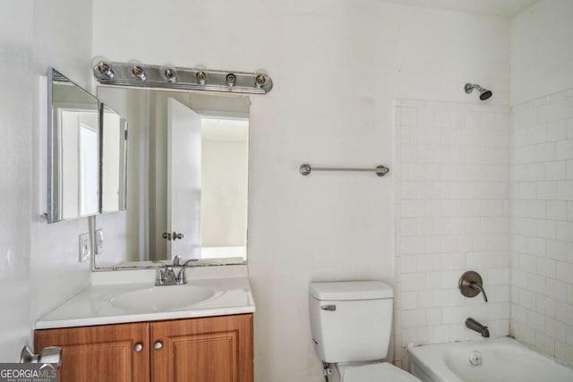 full bathroom featuring tiled shower / bath combo, toilet, and vanity