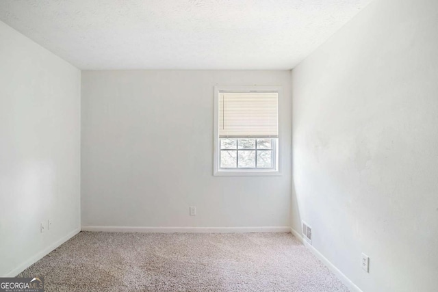 unfurnished room with carpet floors and a textured ceiling