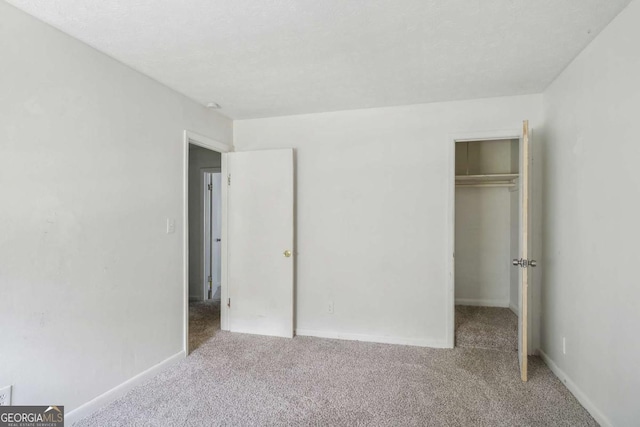 unfurnished bedroom featuring light carpet and a closet