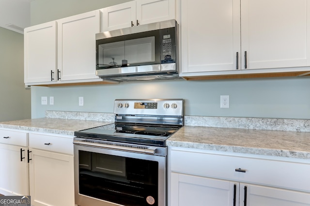 kitchen with appliances with stainless steel finishes and white cabinetry