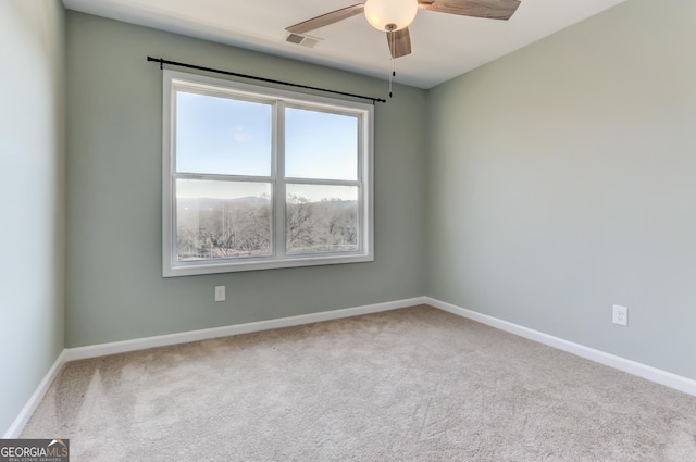 empty room featuring carpet flooring and ceiling fan