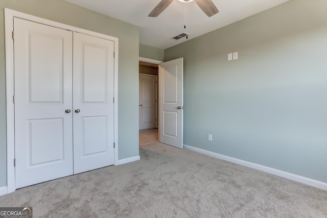 unfurnished bedroom with light carpet, a closet, and ceiling fan