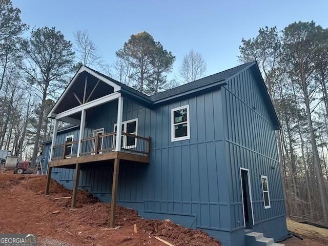 view of side of home with board and batten siding and a wooden deck