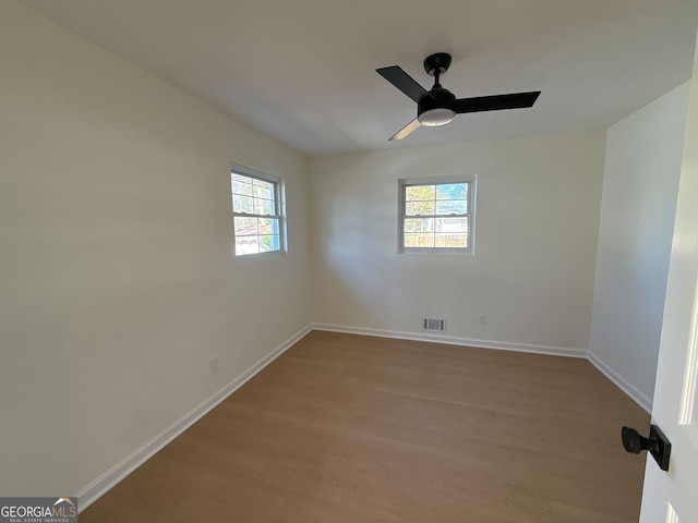 unfurnished room featuring plenty of natural light, ceiling fan, and wood-type flooring