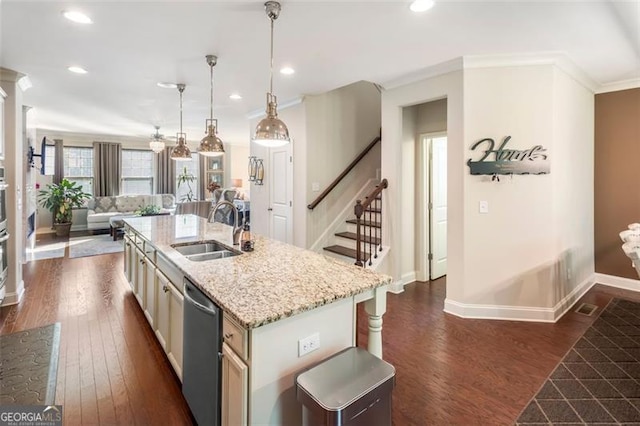 kitchen with dishwasher, a kitchen island with sink, sink, dark hardwood / wood-style floors, and decorative light fixtures