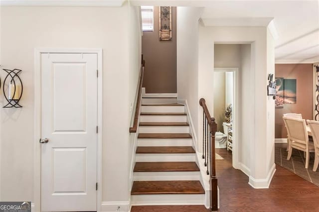 stairway featuring wood-type flooring and ornamental molding