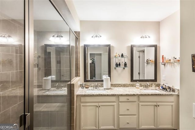 bathroom featuring a shower with door and vanity