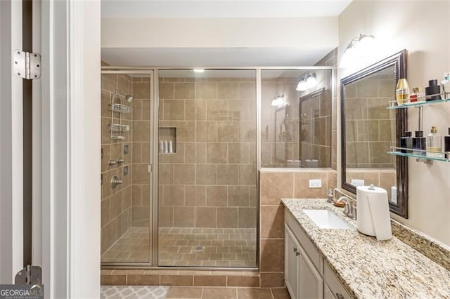 bathroom featuring tile patterned floors, vanity, and a shower with shower door